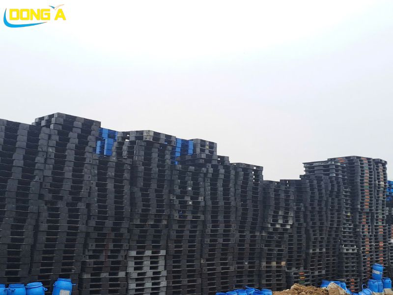 Pallet nhựa đen 1100x1100mm đang được sử dụng trong kho hàng logistics quy mô lớn